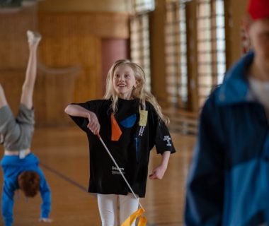 Children having fun in a school gym, with gymnastics and playful activities.